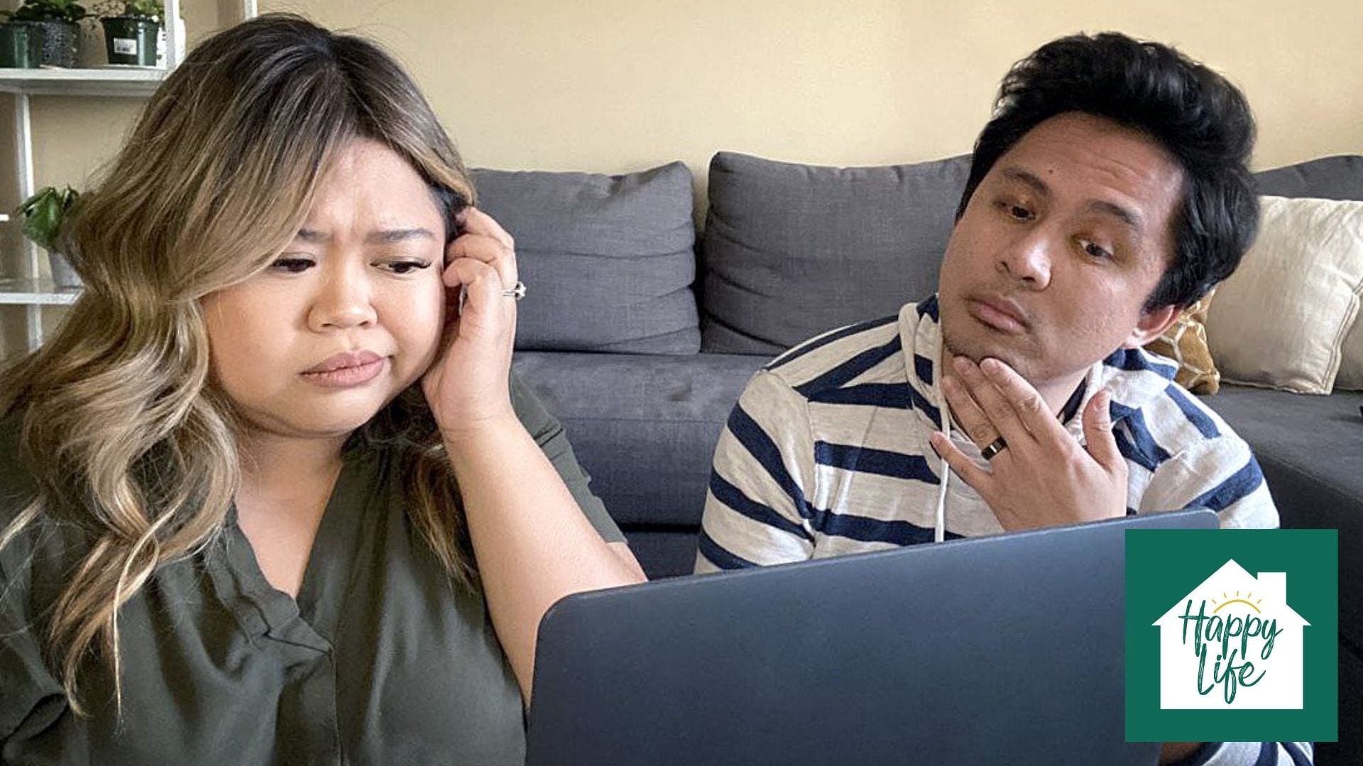 A newly married couple looking at a laptop and making a decision together.