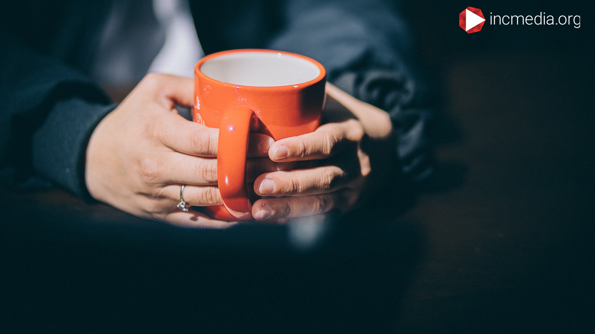 hand holding orange mug