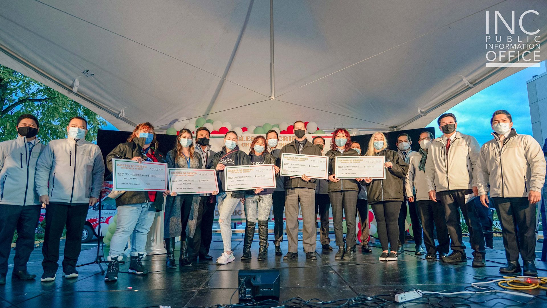 Representatives from various shelters of the Lookout Housing and Health Society stand on stage as they receive the cheque donations from the Church Of Christ.
