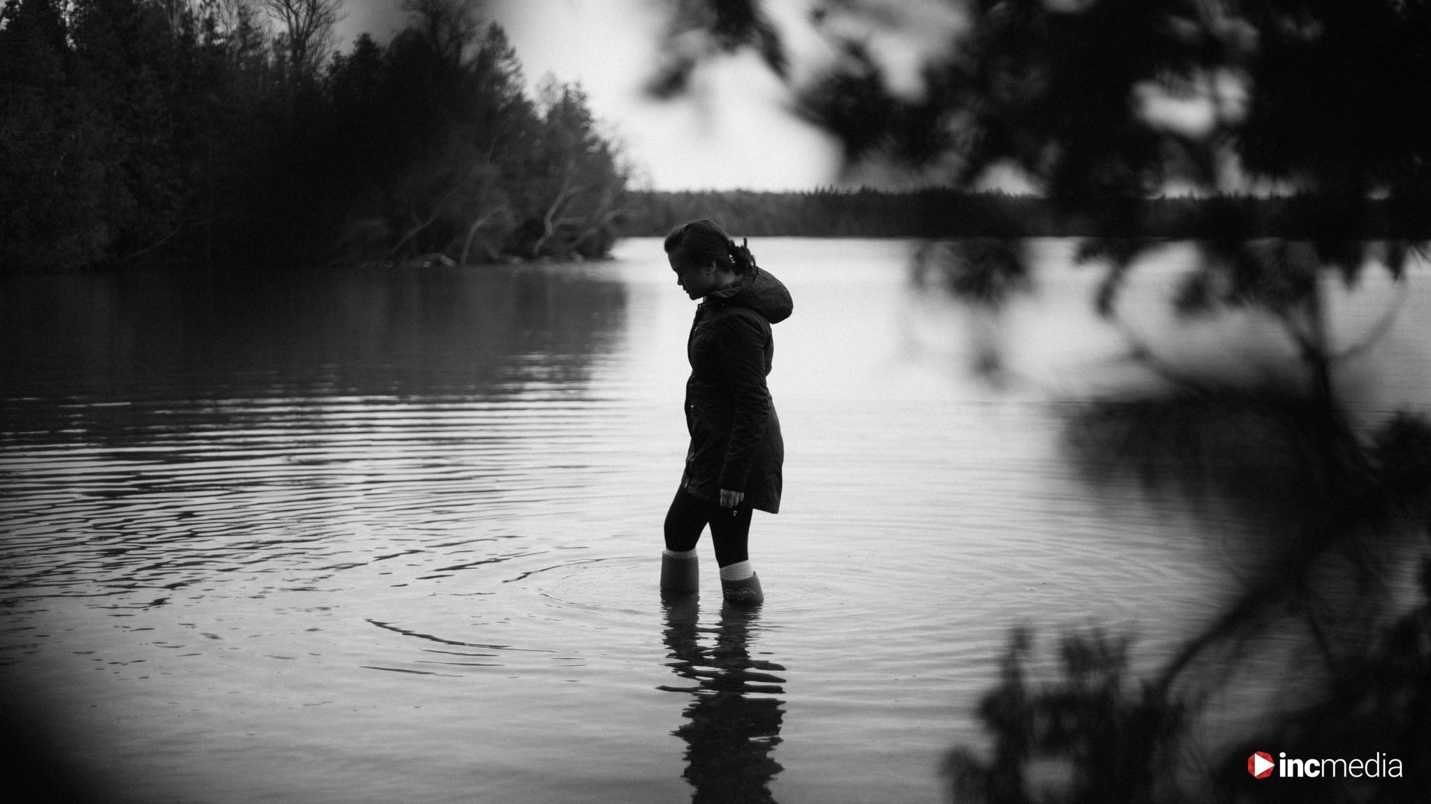 woman thinking while walking in body of water