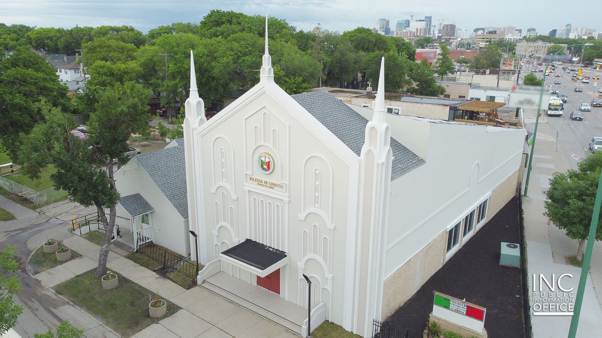 A renovated chapel stands majestically in the neighborhood with three tall spires and the Church Of Christ seal on the facade.